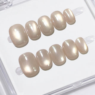 Close-up of EyeCandys Moon Syrup press on nails featuring semi-sheer jelly nude tone with soft pearly cat-eye glow on a white background.