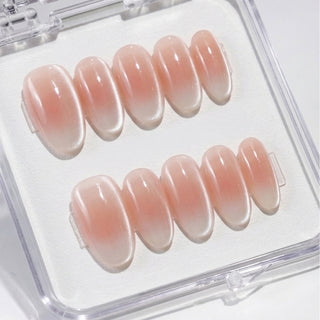 Close-up of EyeCandys Cloud Nine press on nails featuring milky white baby boomer gradient with velvety cat-eye shimmer and soft magnetic glow on a white background.