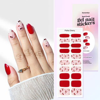 Hand with EyeCandys Petite Cherry Gel Nail Stickers featuring a mix of bold red and translucent pink with cherry dot accents. Semi-cured gel nails offer a salon-quality finish that lasts up to 2 weeks. Cute and playful design perfect for spring and summer nail looks.