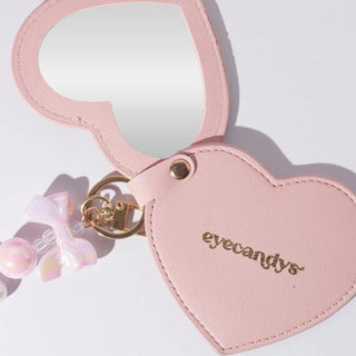 Pink EyeCandys heart-shaped compact mirror — stylish, portable makeup accessory for on-the-go beauty