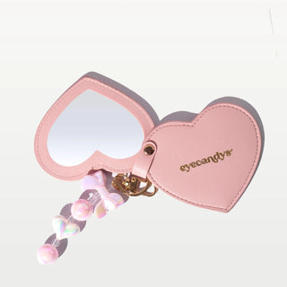 Pink EyeCandys heart-shaped compact mirror, perfect for travel and quick makeup touch-ups