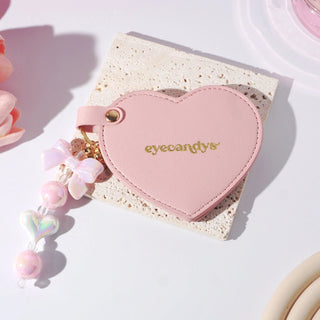 Stylish pink EyeCandys heart-shaped makeup mirror, portable beauty accessory for everyday use