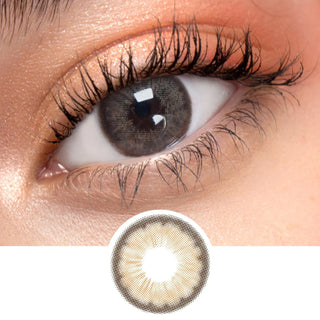 Close up shot of a model with natural dark eyes wearing EyeCandys Pink Label Angel Brown colored contact lens complemented by natural eye make up next to a cutout of the lens design