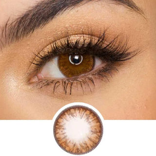 Pink Label Grang Big Brown color contact lens on top of a dark eye paired with subtle eye makeup and curled wispy eyelashes, above the contact lens design.