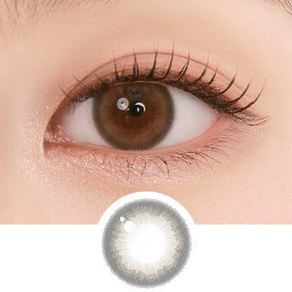 Close-up shot of model's eye adorned with Chuu Pompon Pop Bubble Brown (10pk)daily color contact lenses with prescription, complemented by natural eye makeup, showing the brightening and enlarging effect of the circle contact lens on dark brown eyes, above a cutout of the contact lens pattern with limbal ring on a white background.