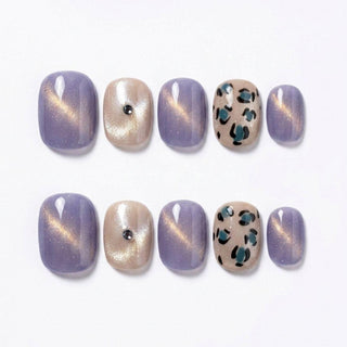 EyeCandys Purr-ple Reign Press-On Nails feature handmade gel nails in shimmery lavender, shimmery beige with rhinestones, and beige with teal and black leopard print for a salon-worthy look. Arranged neatly in two rows.