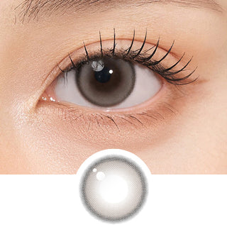 Close-up shot of model's eye adorned with Gemhour Themis Nude Grey daily color contact lenses with prescription, complemented by clean eye makeup, showing the brightening and enlarging effect of the circle contact lens on dark brown eyes, above a cutout of the contact lens pattern with limbal ring on a white background.