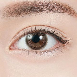 Close-up shot of model's eye adorned with Topards 1-Day Date Topaz (10pk) daily color contact lenses with prescription, complemented by minimalist eye makeup, showing the brightening and enlarging effect of the circle contact lens on dark brown eyes.