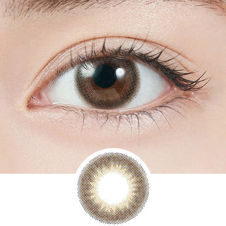 Close-up shot of model's eye adorned with Topards 1-Day Date Topaz (10pk) daily color contact lenses with prescription, paired with clean-girl eye makeup, showing the brightening and enlarging effect of the circle contact lens on dark brown eyes, above a cutout of the contact lens with limbal ring on a white background.