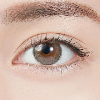 Close-up shot of model's eye adorned with Topards 1-Day Grege Quartz (10pk) daily color contact lenses with prescription, complemented by minimalist eye makeup, showing the brightening and enlarging effect of the circle contact lens on dark brown eyes.