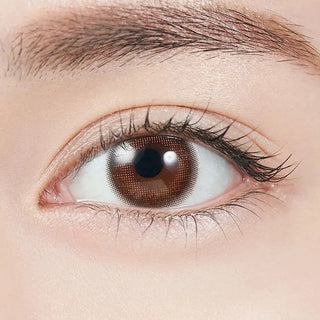 Close-up shot of model's eye adorned with Topards 1-Day Strawberry Quartz (10pk) daily color contact lenses with prescription, complemented by minimalist eye makeup, showing the brightening and enlarging effect of the circle contact lens on dark brown eyes.