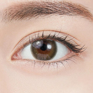 Close-up shot of model's eye adorned with Topards 1-Day Twin Topaz (10pk) daily color contact lenses with prescription, complemented by minimalist eye makeup, showing the brightening and enlarging effect of the circle contact lens on dark brown eyes.