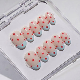 The EyeCandys Unbothered Press-On Nails feature a light pink base, sky blue French tips, and red dots in a clear box—perfect for achieving a salon-quality gel manicure at home.