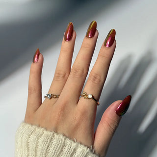 Hand wearing EyeCandys Apple Pie Gel Nail Sticker – iridescent red nails with golden chrome shimmer. Warm, festive DIY gel manicure with multi-dimensional shine, ideal for holidays, cozy looks, or elegant everyday nails. Vegan, non-toxic, and long-lasting.
