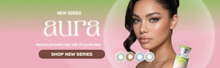 Promotional banner for the Aura contact lens series featuring a model wearing light gray lenses, four lens color options, soft pink and green gradient background, and a Shop Now button.