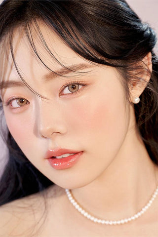A close-up of a model demonstrating a natural makeup look with Ann365 Buttercup 1-Day Beige (10pk) circle colour contacts, highlighting how well the contact lenses blend with her dark eyes.