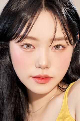 A close-up of a model demonstrating a natural makeup look with Ann365 Buttercup 1-Day Grey (10pk) circle colour contacts, highlighting how well the contact lenses blend with her dark eyes.