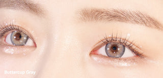A close-up of a model demonstrating a natural makeup look with Ann365 Buttercup Grey circle colour contacts, highlighting how well the contact lenses blend with her dark eyes.