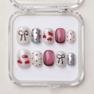 EyeCandys Cherry Bomb press on nails featuring pearlescent white base with sculpted 3D cherries, cat eye nails, and cherry red glitter accents.