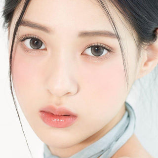 Asian model demonstrating a K-idol-inspired look with 1-Day Pebble Grey coloured contact lenses, highlighting the instant brightening and enlarging effect of the circle contact lenses over dark irises.