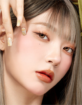 Asian model wearing Dollring Brown prescription contact lens on her naturally dark brown eyes with a hint of coral lipstick for a unique look