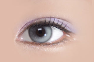 Close-up of eye wearing Eyecandys Bunnie Milky Ash prescription colored contact lens, soft grey tones blending naturally with dark iris