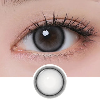 Close-up of eye with long lashes and natural makeup wearing EyeCandys I-Girl One Pick Natural Gray contact lens, showing lens design below