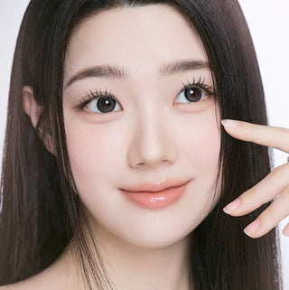 Model showcasing EyeCandys I-Girl One Pick Natural Gray contact lenses with natural makeup and long lashes