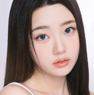 Close-up of model’s eyes with long lashes wearing EyeCandys I-Girl One Pick Natural Soda contact lenses and natural makeup