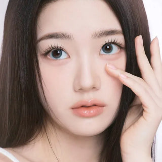 Model with natural makeup and long lashes wearing EyeCandys I-Girl One Pick Natural Soda contact lenses for a subtle eye enhancement