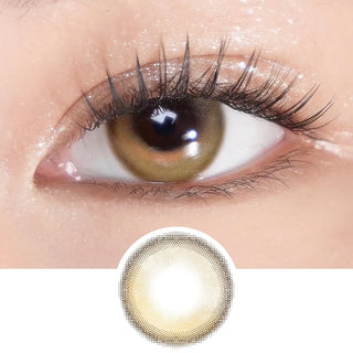 Close-up of eye with long lashes wearing EyeCandys Sunlit Hazel prescription contact lens – warm golden-brown tones with subtle iris enlargement and natural sparkle. Lens design shown below.
