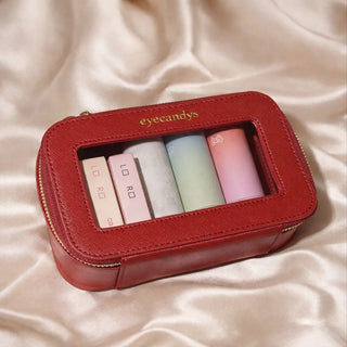 Eyecandys Weekender Essentials Case in carmine red with gold snowflake hardware, travel-ready pouch for beauty essentials, contact lenses, and gel nail stickers.