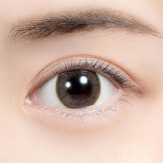 Close-up shot of model's eye adorned with Feliamo 1-Day Airy Beige (10pk) color contact lenses with prescription, complemented by minimalist eye makeup, showing the brightening and enlarging effect of the circle contact lens on dark brown eyes.