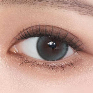 Close-up shot of model's eye adorned with Gemhour Demeter 1-Day Ocean Blue (10pk) color contact lenses with prescription, complemented by minimalist eye makeup, showing the brightening and enlarging effect of the circle contact lens on dark brown eyes.