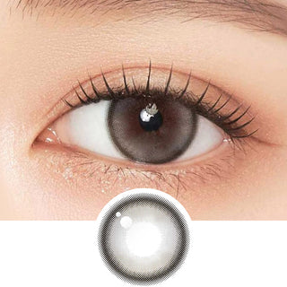 Close-up shot of model's eye adorned with Gemhour Demeter 1-Day Pebble Grey (10pk) daily color contact lenses with prescription, complemented by clean eye makeup, showing the brightening and enlarging effect of the circle contact lens on dark brown eyes, above a cutout of the contact lens pattern with limbal ring on a white background.