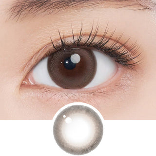 Close-up shot of model's eye adorned with Gemhour Freyja 1-Day Mood Brown (10pk) daily color contact lenses with prescription, complemented by clean eye makeup, showing the brightening and enlarging effect of the circle contact lens on dark brown eyes, above a cutout of the contact lens pattern with limbal ring on a white background.