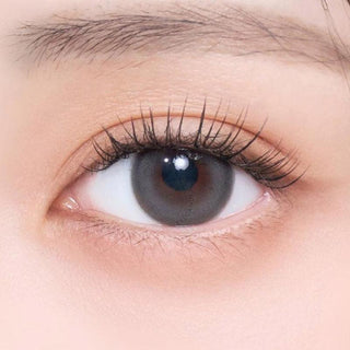 Close-up shot of model's eye adorned with Gemhour Freyja 1-Day Mood Grey (10pk) color contact lenses with prescription, complemented by minimalist eye makeup, showing the brightening and enlarging effect of the circle contact lens on dark brown eyes.
