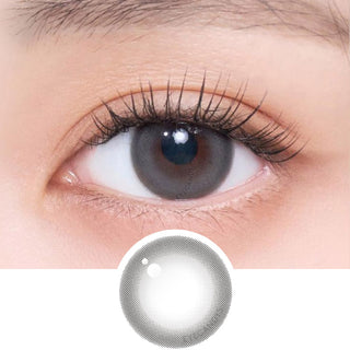 Close-up shot of model's eye adorned with Gemhour Freyja 1-Day Mood Grey (10pk) daily color contact lenses with prescription, complemented by clean eye makeup, showing the brightening and enlarging effect of the circle contact lens on dark brown eyes, above a cutout of the contact lens pattern with limbal ring on a white background.
