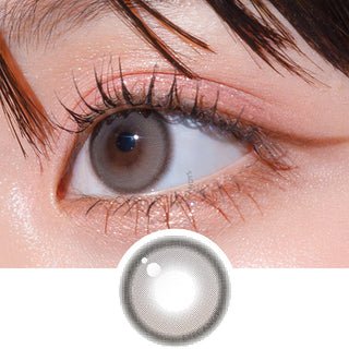 Close-up shot of model's eye adorned with Gemhour Hecate 1-Day Taupe Grey (10pk) daily color contact lenses with prescription, complemented by clean eye makeup, showing the brightening and enlarging effect of the circle contact lens on dark brown eyes, above a cutout of the contact lens pattern with limbal ring on a white background.