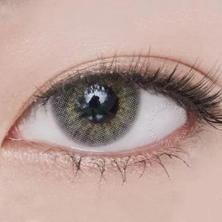 Close-up shot of a model wearing Blenz Chic Grey blended colored contact lens in one eye that is naturally dark-brown, paired with minimal Korean-inspired eye makeup.