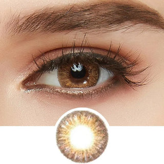 Tri-Color light brown color contact lens on top of a dark eye paired with light brown eyeshadow and curled wispy eyelashes, above the prescription contact lens pattern.