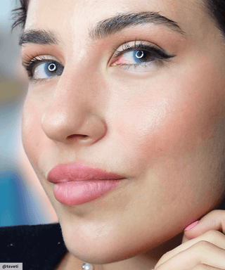Model wearing Glossy Blue colored contacts, showing the natural yet transformative effect on naturally dark eyes.