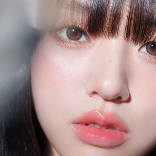 Asian model demonstrating a K-idol-inspired look with Gemhour Hecate 1-Day Sand Brown (10pk) coloured contact lenses, highlighting the instant brightening and enlarging effect of the circle contact lenses over dark irises.