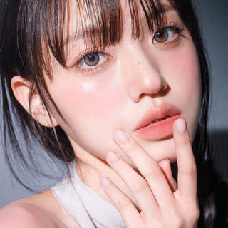 Asian model demonstrating a K-idol-inspired look with 1-Day Taupe Grey coloured contact lenses, highlighting the instant brightening and enlarging effect of the circle contact lenses over dark irises.