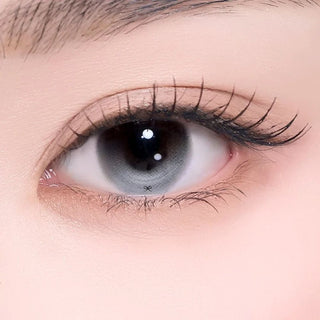 Extreme close-up of an eye wearing a gray gradient contact lenses.