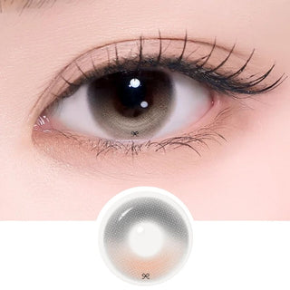 Close-up of gray-latte contact lens on eye with matching lens sample.