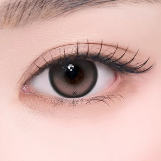Close-up of an eye wearing red-brown contact lens with a dark limbal and subtle gradient pattern.