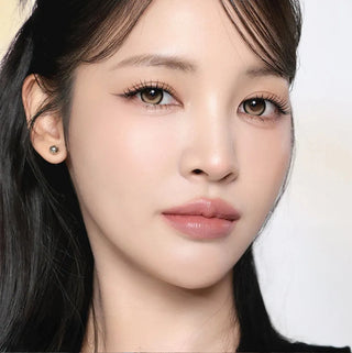 Model with natural makeup and long lashes wearing EyeCandys i-Sha Dekame Kiss Me 1-Day Yuzu Boom Brown colored contact lenses
