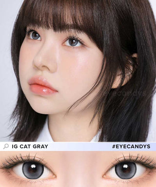 A female model with natural dark eyes wearing i-Girl IG Cat Grey contact lenses, complemented by subtle eyeshadow and pink lipstick and Close-up image showcases the model's eyes adorned with the same grey contact lenses