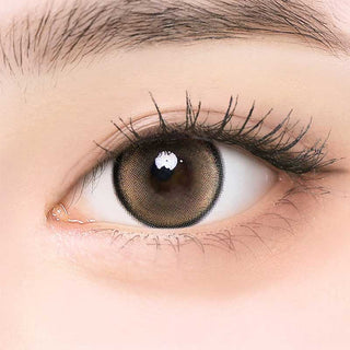i-Girl IG Cream Brown color contact lens on top of a dark eye paired with subtle eye makeup and curled wispy eyelashes